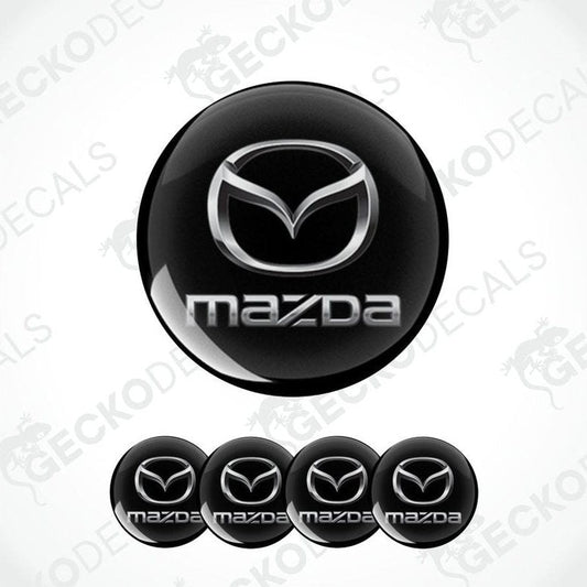 Set of Mazda logos on black round stickers with a white background.