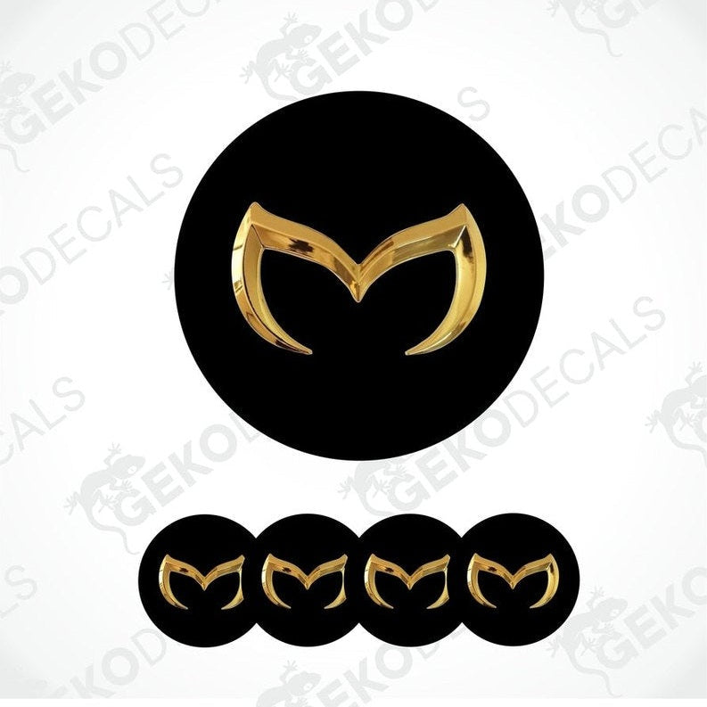 Set of four black and gold Mazda car wheel decals and one emblem decal.