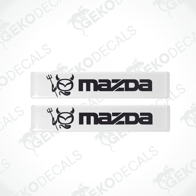 Two white and black vinyl decals with the Mazda logo.