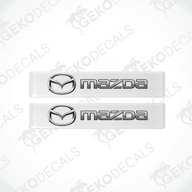 Two white vinyl stickers with the Mazda logo in the center.