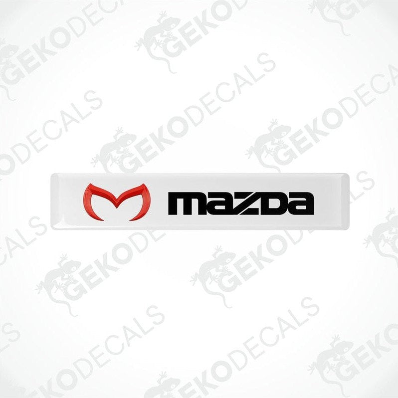  White vinyl stickers with a red and black Mazda logo on them.