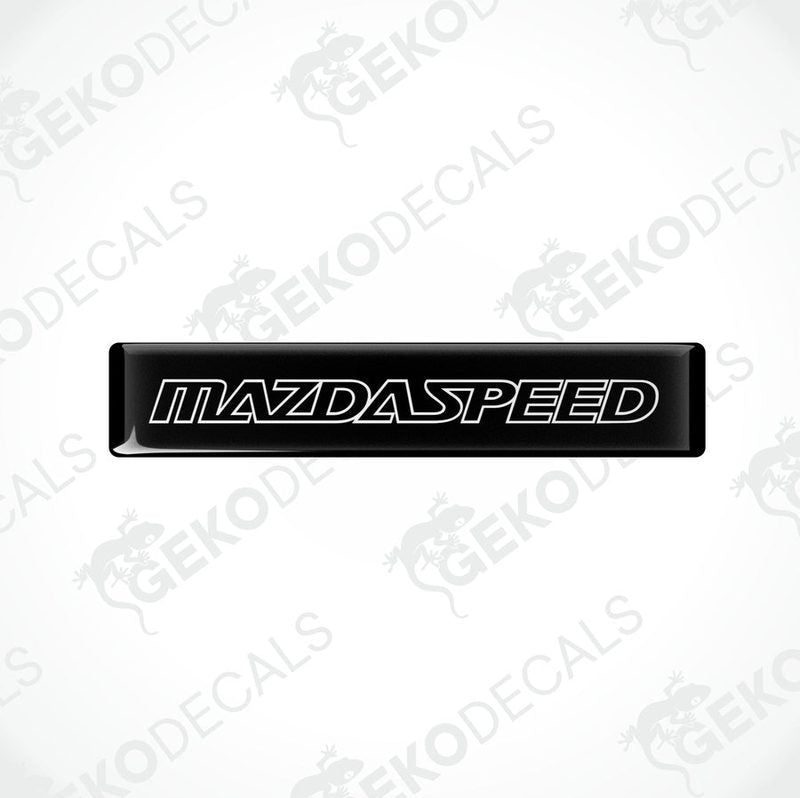 Black rectangular car decals with 'MAZDASPEED' written in white letters.