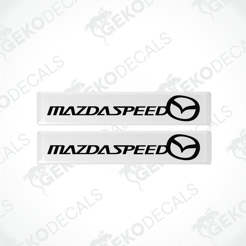 Two white vinyl stickers with the MazdaSpeed logo in black.
