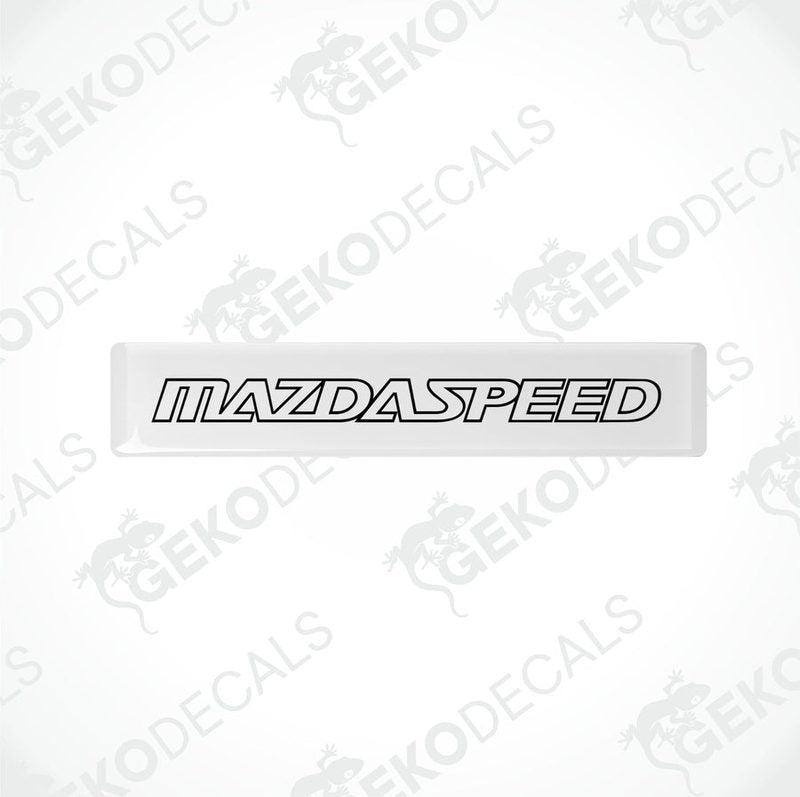 White rectangular car decals with 'MAZDASPEED' written in black letters.