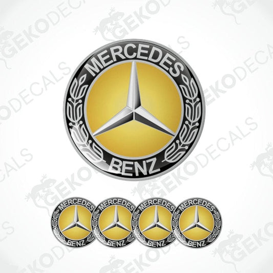 A set of four vinyl decals with a polyurethane coating featuring the Mercedes-Benz logo in gold, black, and silver colors.