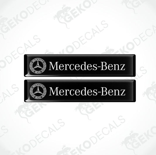 Two black vinyl stickers with the Mercedes-Benz logo printed on them.