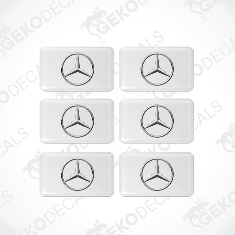 A set of six withe vinyl stickers with a Mercedes-Benz logo on each.
