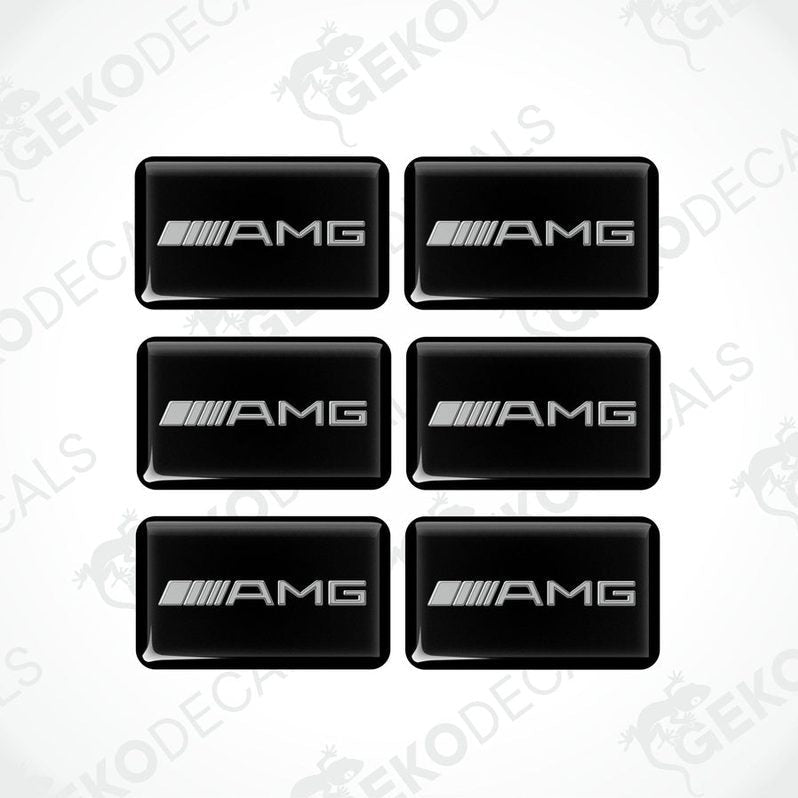 A set of six black rectangular car decals with the AMG logo in grey.