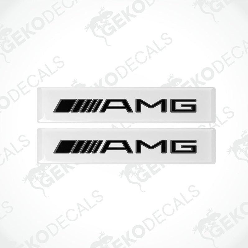Two white vinyl stickers with the Mercedes-Benz AMG logo on a black background.