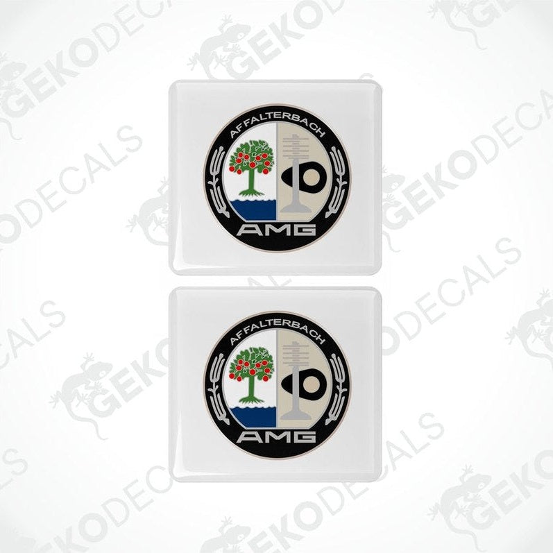 Two white square car decals with a black and green emblem AMG AFFALTERBACH