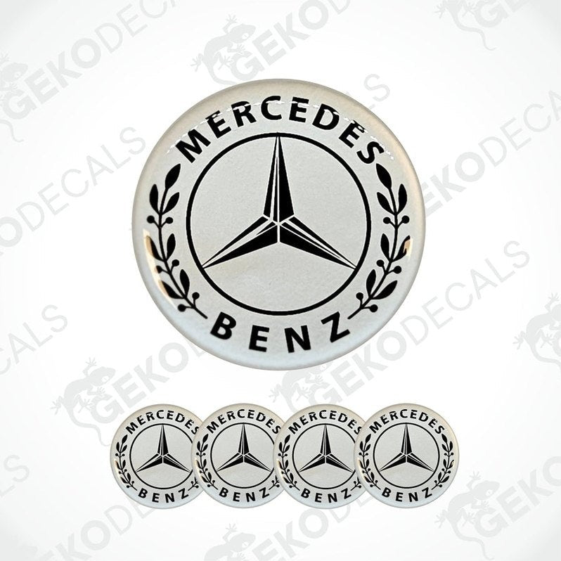 A set of white vinyl decals with the Mercedes-Benz logo, including one larger decal with leaf patterns around the star and four smaller ones.