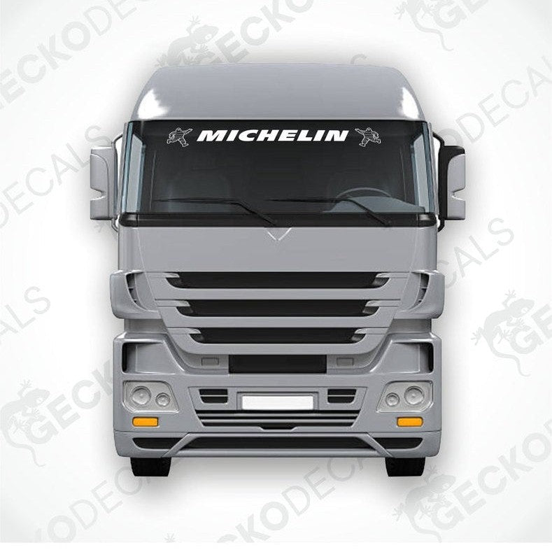 A die cut decal with the Michelin logo displayed on the front of a gray truck windshield.