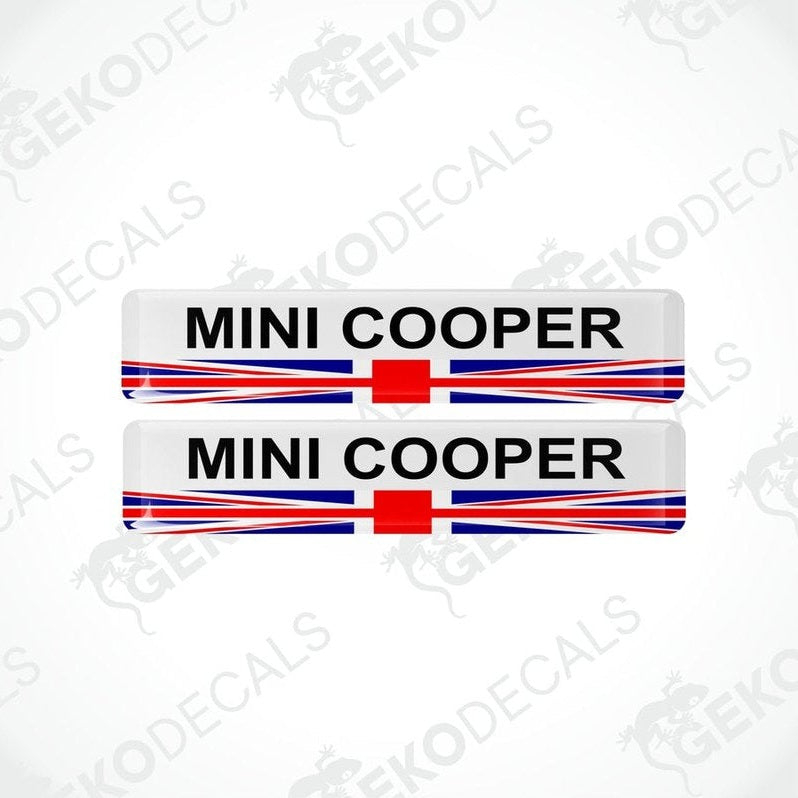 A set of two vinyl stickers with a MINI COOPER branding and a design resembling the British flag in red, white, and blue.