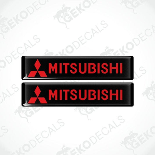 Two rectangular black vinyl decals with the red Mitsubishi logo and text 'MITSUBISHI' printed in capital letters.