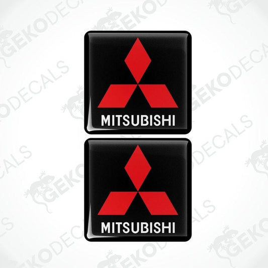 Two black vinyl stickers with a red Mitsubishi logo on each, placed against a white background with the text 'MITSUBISHI' below each sticker.