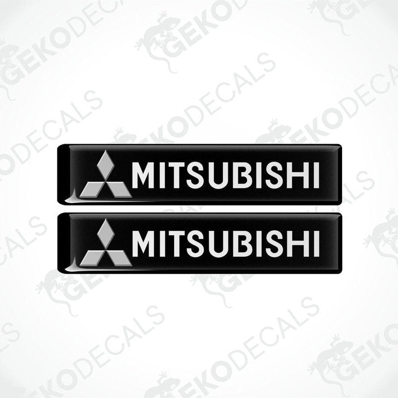 Two black vinyl stickers with the Mitsubishi brand logo on them.