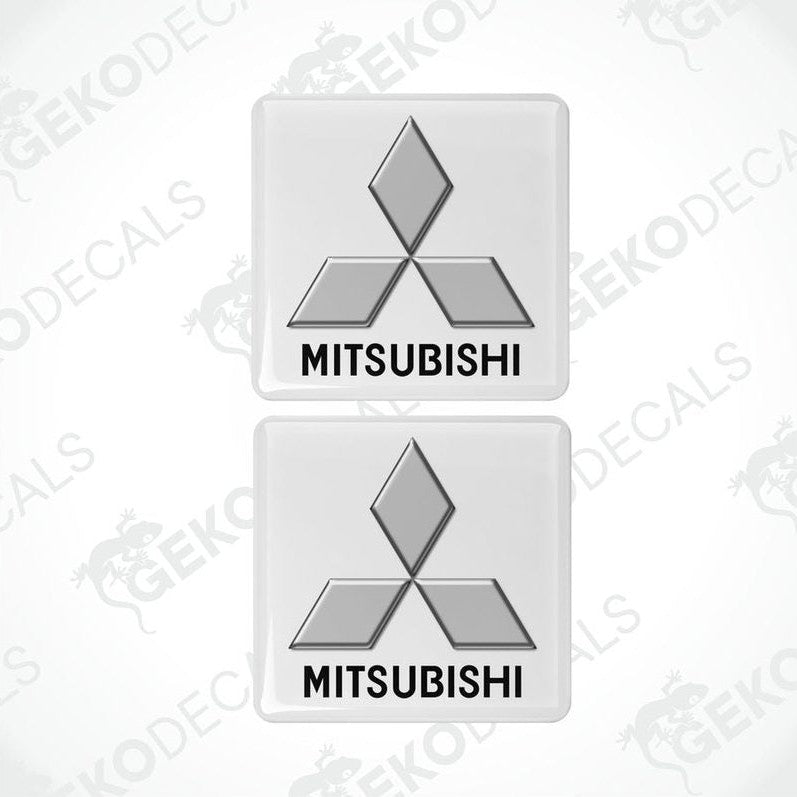 Two white vinyl stickers with a black Mitsubishi logo on each, placed against a white background.