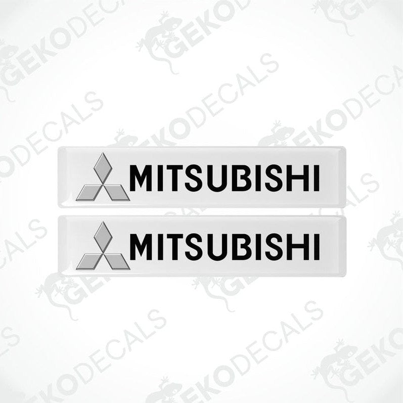 Two white vinyl stickers with the Mitsubishi brand logo on them.