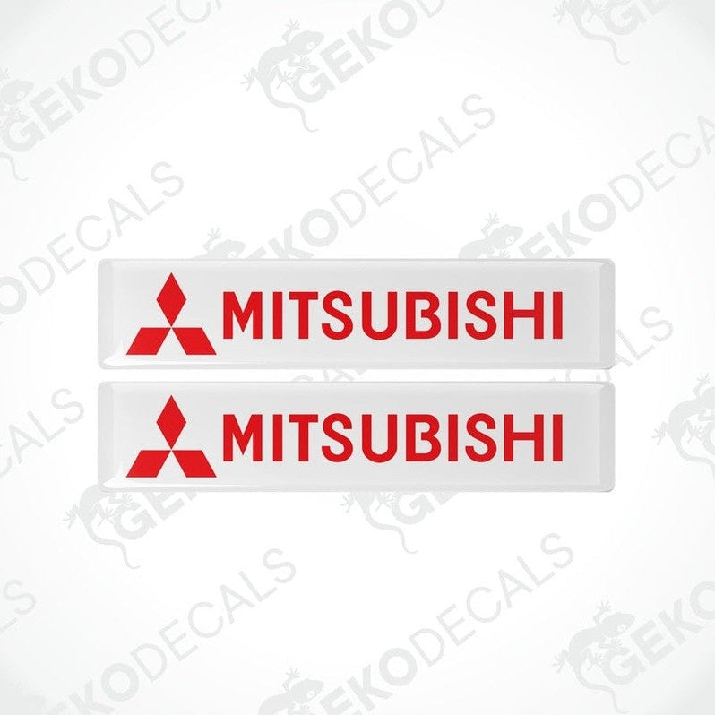 Two rectangular white vinyl decals with the red Mitsubishi logo and text 'MITSUBISHI' printed in capital letters.