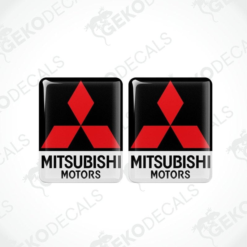 Two square-shaped decals with the Mitsubishi Motors logo in red and white on a black background.