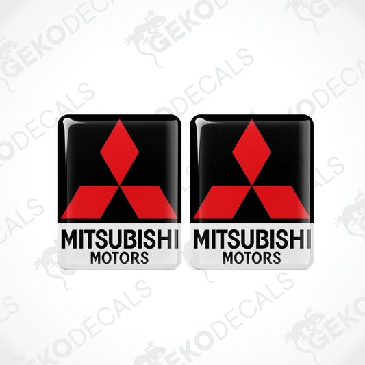 Two square-shaped decals with the Mitsubishi Motors logo in red and white on a black background.