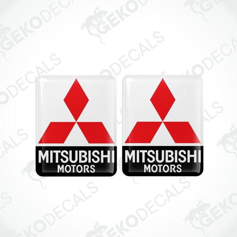Two square-shaped decals with the Mitsubishi Motors logo in red and black on a white background.