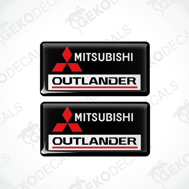 Two black vinyl stickers with red and white Mitsubishi Outlander branding.