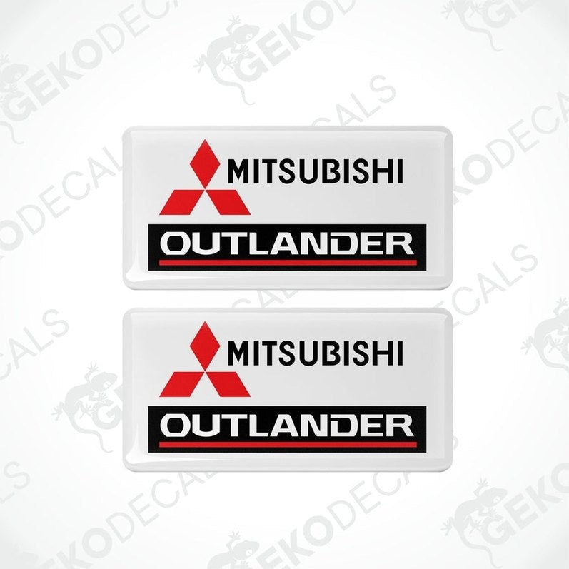 Two white vinyl stickers with red and black Mitsubishi Outlander branding.