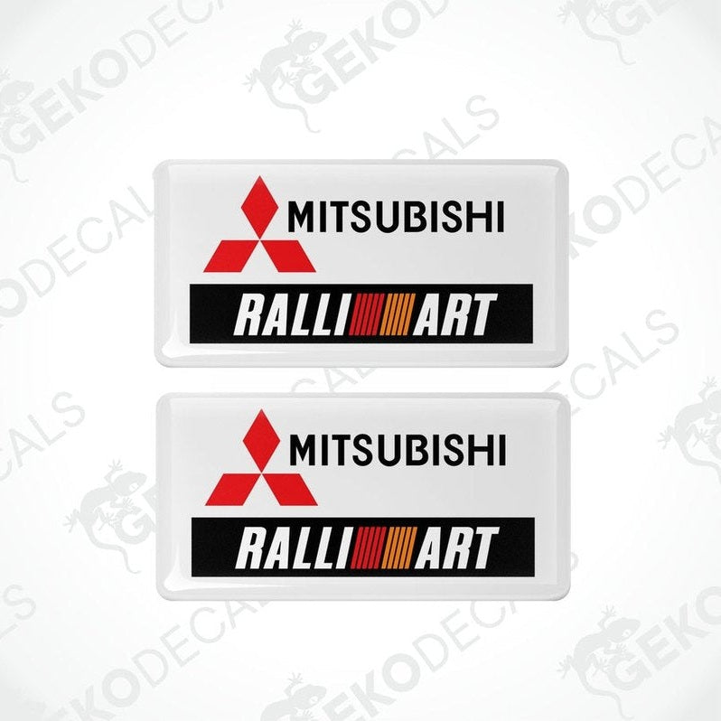 Two white vinyl stickers with the Mitsubishi Ralliart logo in orange and black.