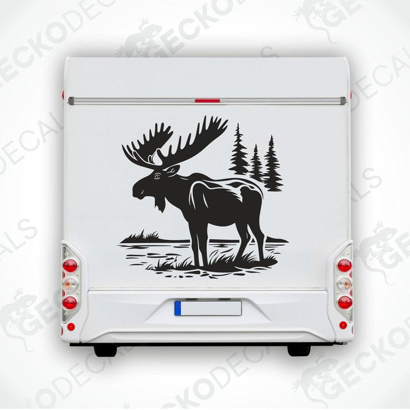 A die cut decal of a moose in a nature setting, delivered on transfer paper, shown applied on the back of a white vehicle.