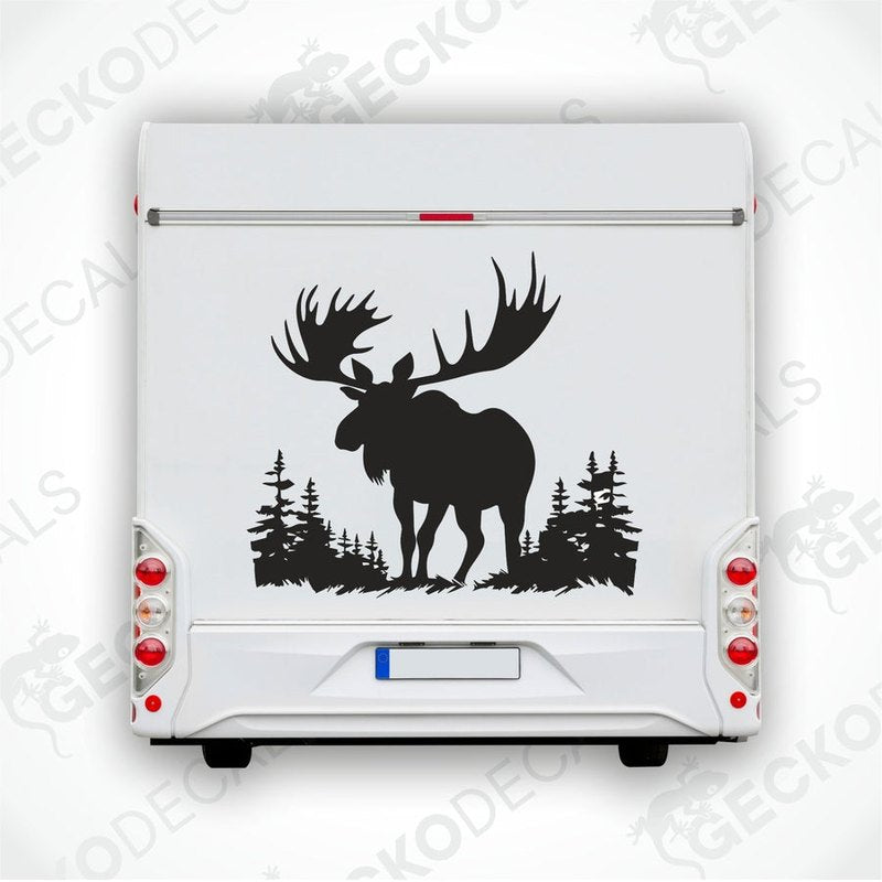 A die cut decal of a moose in a nature setting, with trees in the background, displayed on a white surface.