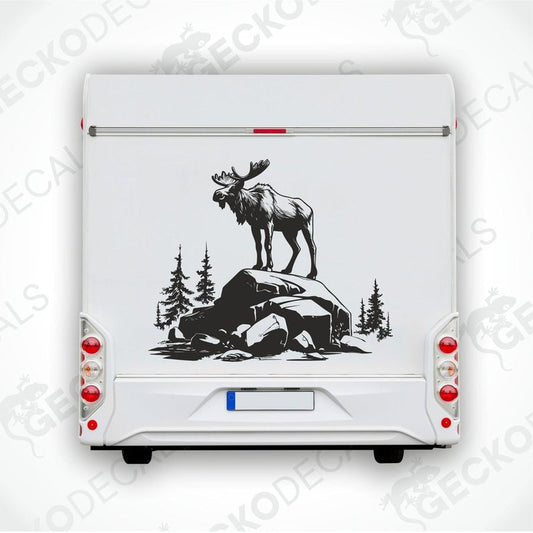 A decal of a moose standing on a rock with a forest and mountains background.
