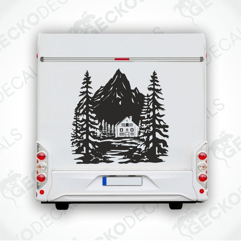 A decal of a mountain house with trees and a mountain in the background, delivered on a white vehicle.