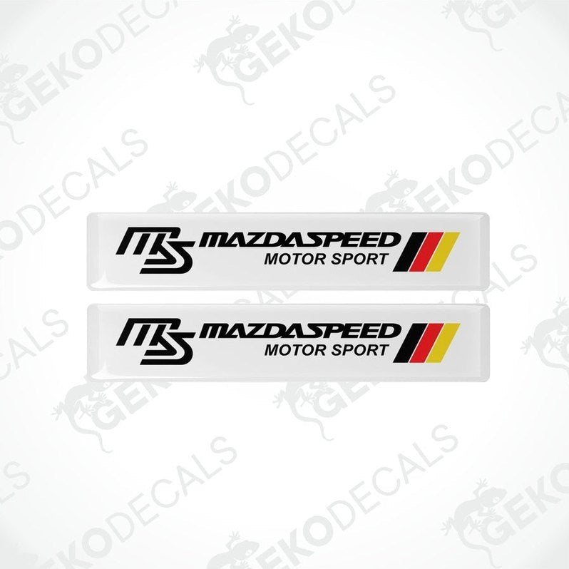 Two white vinyl stickers with red, black, and yellow MazdaSpeed Motor Sport logo, placed on a white background.