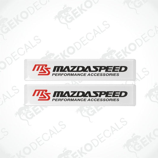 Two white vinyl stickers with the MazdaSpeed Performance Accessories logo in red and black.