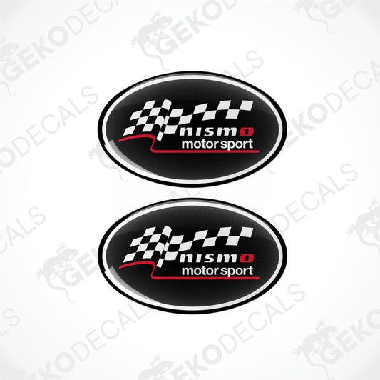 Two oval-shaped decals with a checkered flag design, featuring the text 'NISMO motor sport' in white on a black background.
