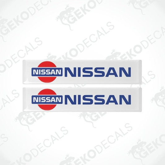 Two vinyl decals with polyurethane coating featuring the NISSAN logo, predominantly red and white in color.