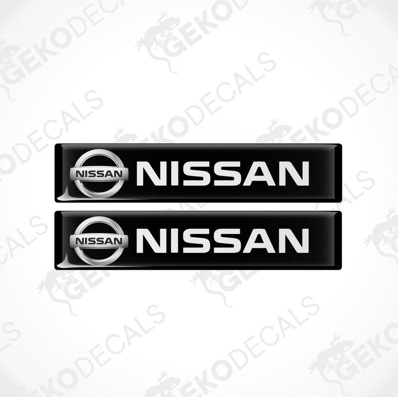 Two rectangular black vinyl decals with the white text 'NISSAN' on them, placed on a white background.