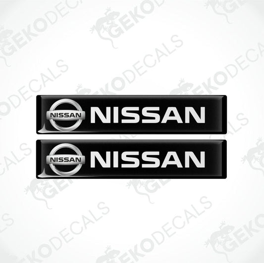 Two rectangular black vinyl decals with the white text 'NISSAN' on them, placed on a white background.