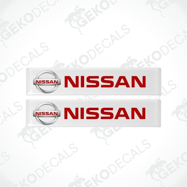Two withe vinyl stickers with the NISSAN logo in red and white.