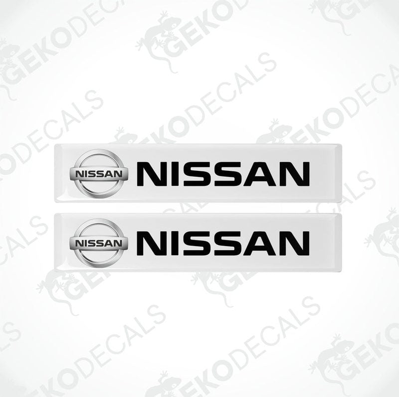 Two rectangular white vinyl decals with the black text 'NISSAN' on them, placed on a white background.