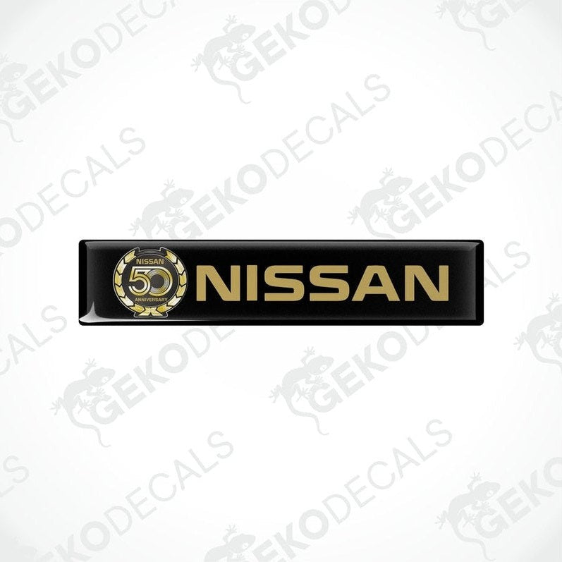 Black vinyl stickers with gold and white text and graphics representing the NISSAN brand, placed against a white background.