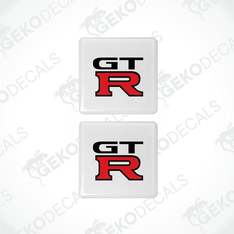 Two white vinyl stickers with the NISSAN GT R logo in red and black.