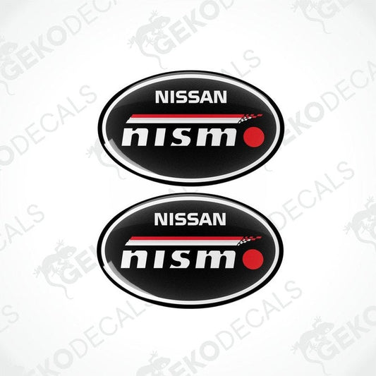 Two oval-shaped vinyl decals with the NISSAN NISMO logo in black, red, and white colors.