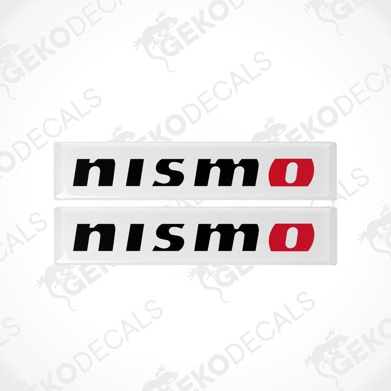 Two white, red, and black vinyl stickers with 'NISSAN NISMO' text and a logo.