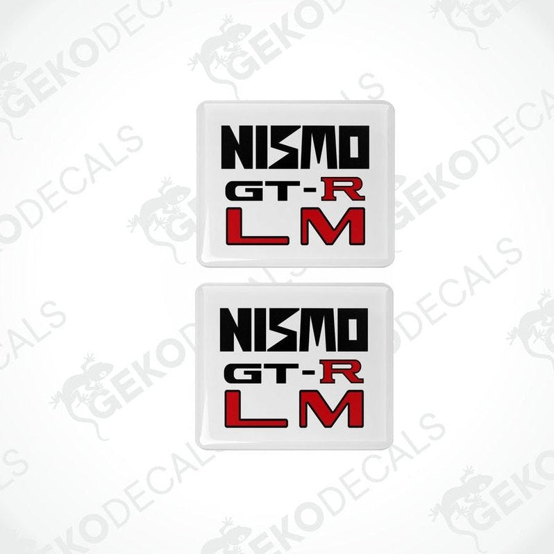 Two square white vinyl decals with 'NISMO GT-R LM' written in black and red text.
