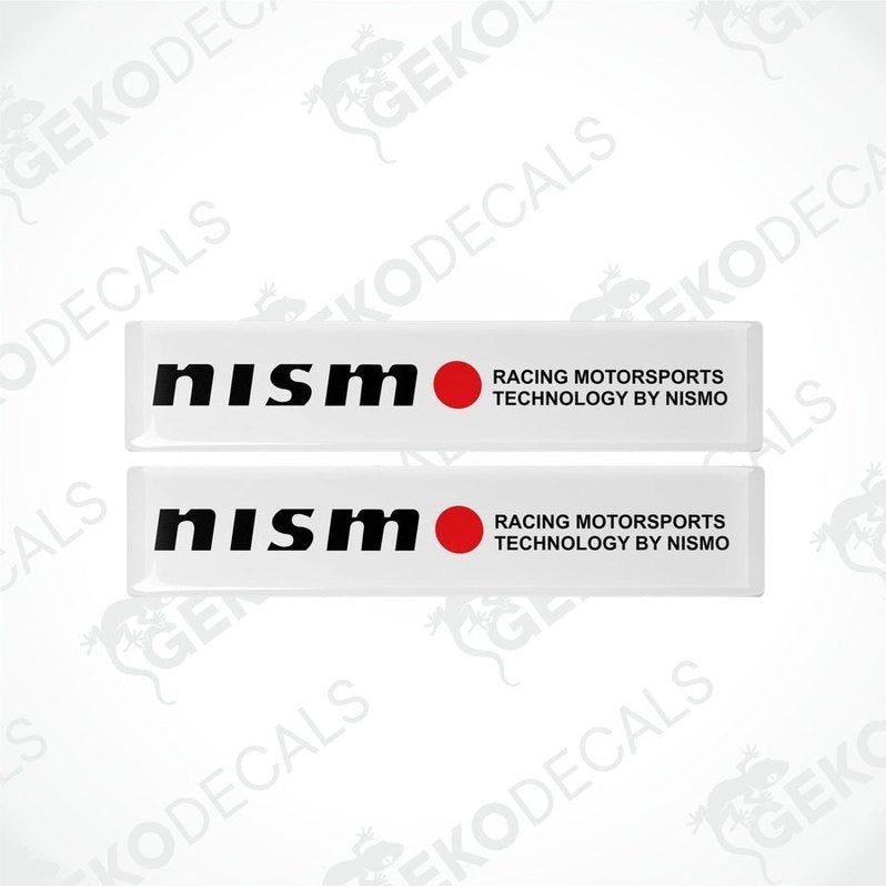 Two white vinyl stickers with red and black text, including 'NISSAN' and 'RACING MOTORSPORTS TECHNOLOGY BY NISMO'. GeckoDecals logo is visible in the corner.