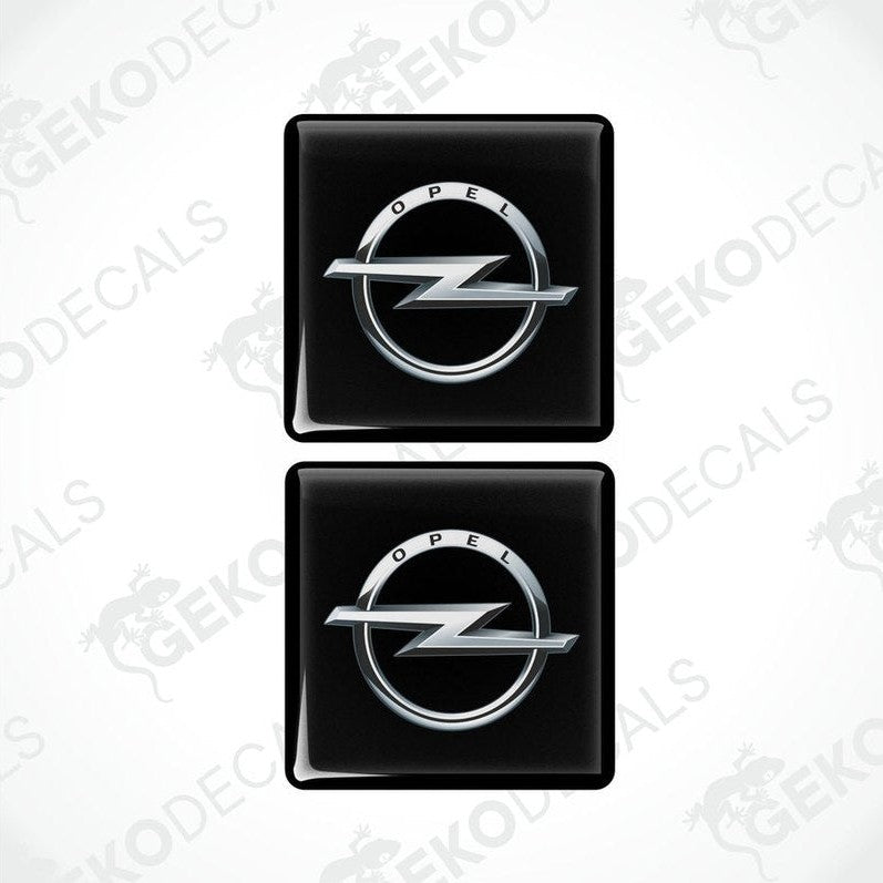 Two black domed stickers with the Opel logo in silver.