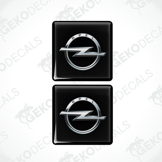 Two black domed stickers with the Opel logo in silver.
