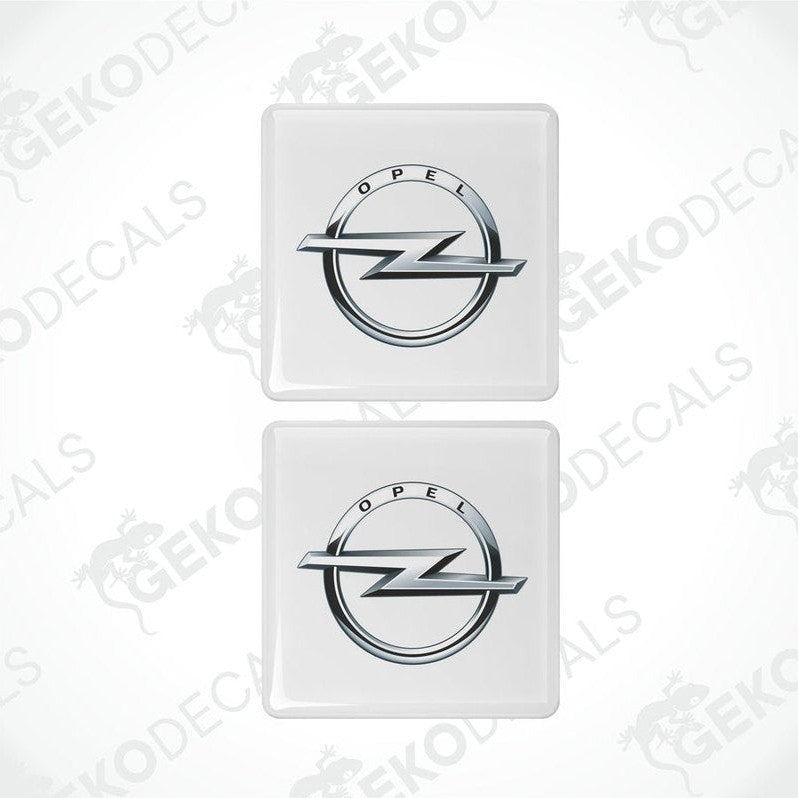 Two withe domed stickers with the Opel logo in silver.